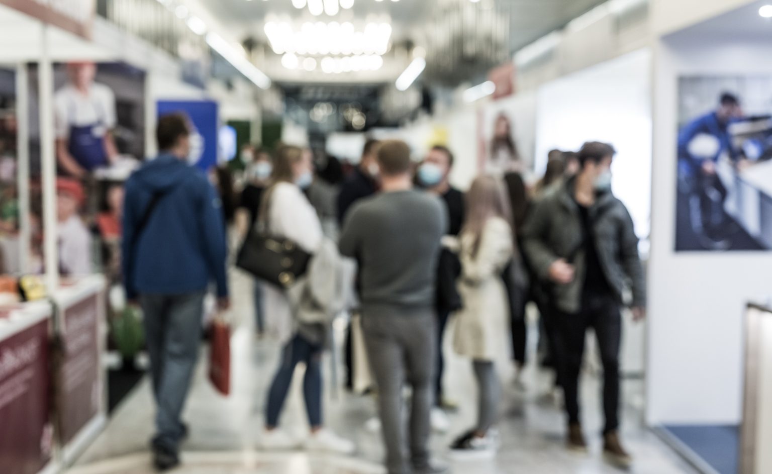 AQE Press Release | ION SENSE Crowded indoor exhibition hall with people walking and talking; several attendees wear face masks.