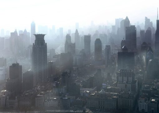 Dense city skyline with tall skyscrapers fading into foggy haze.